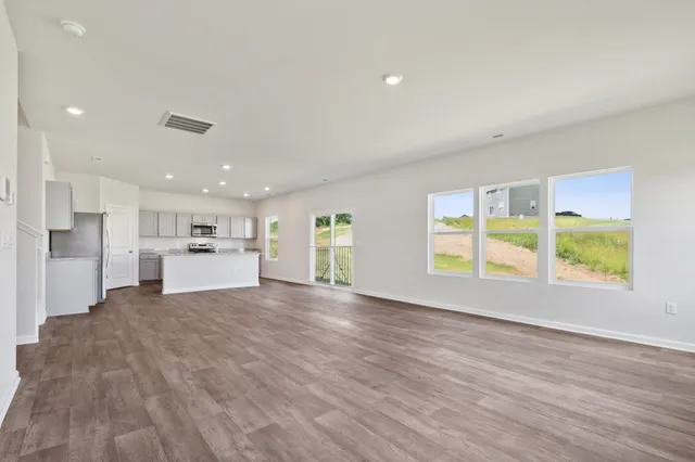 a view of a kitchen with wooden floor and a window