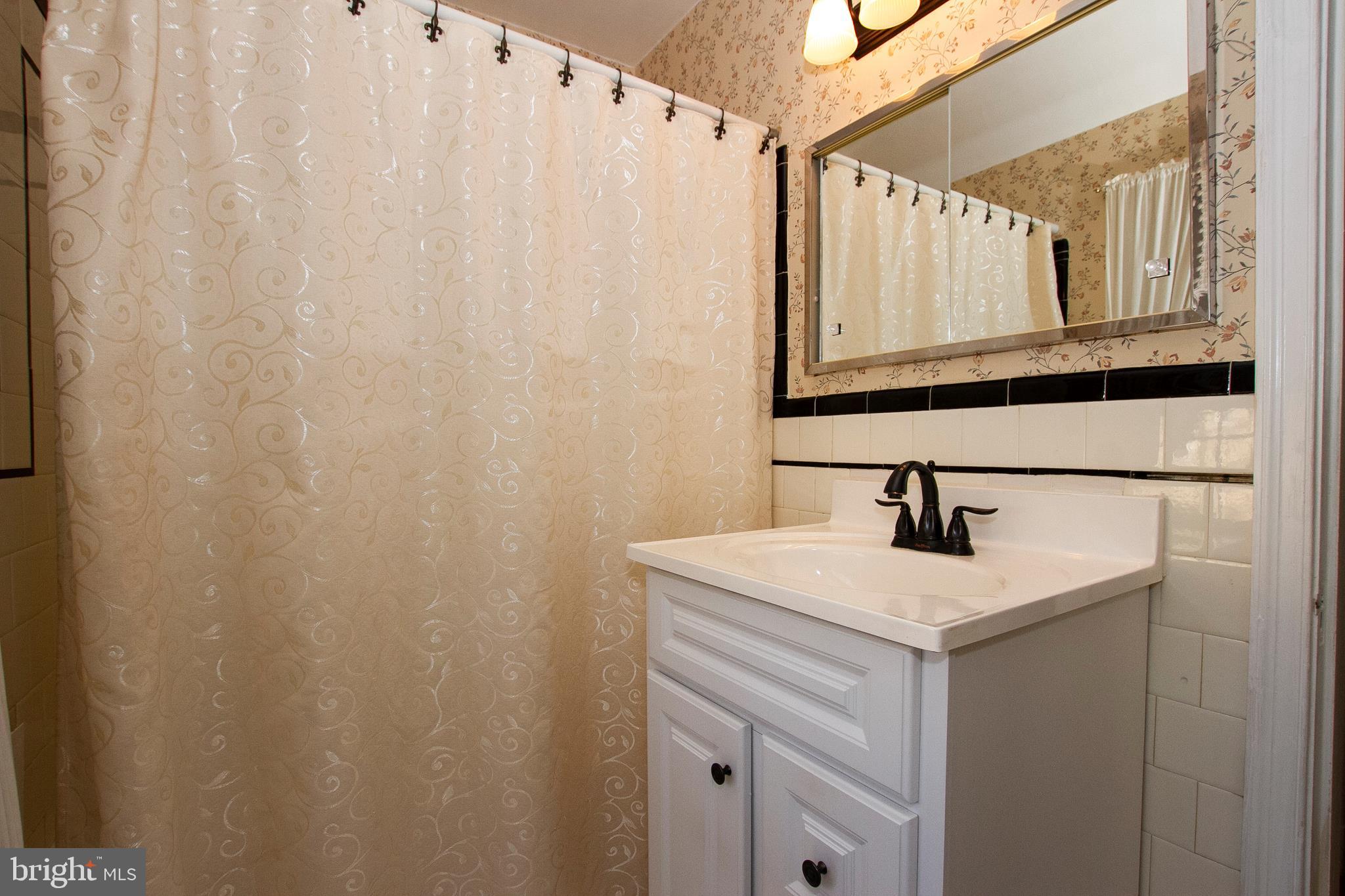 7103 Sheffield Road Baltimore, MD 21212 - Photo 30 of 37 a bathroom with a sink a vanity and a mirror
