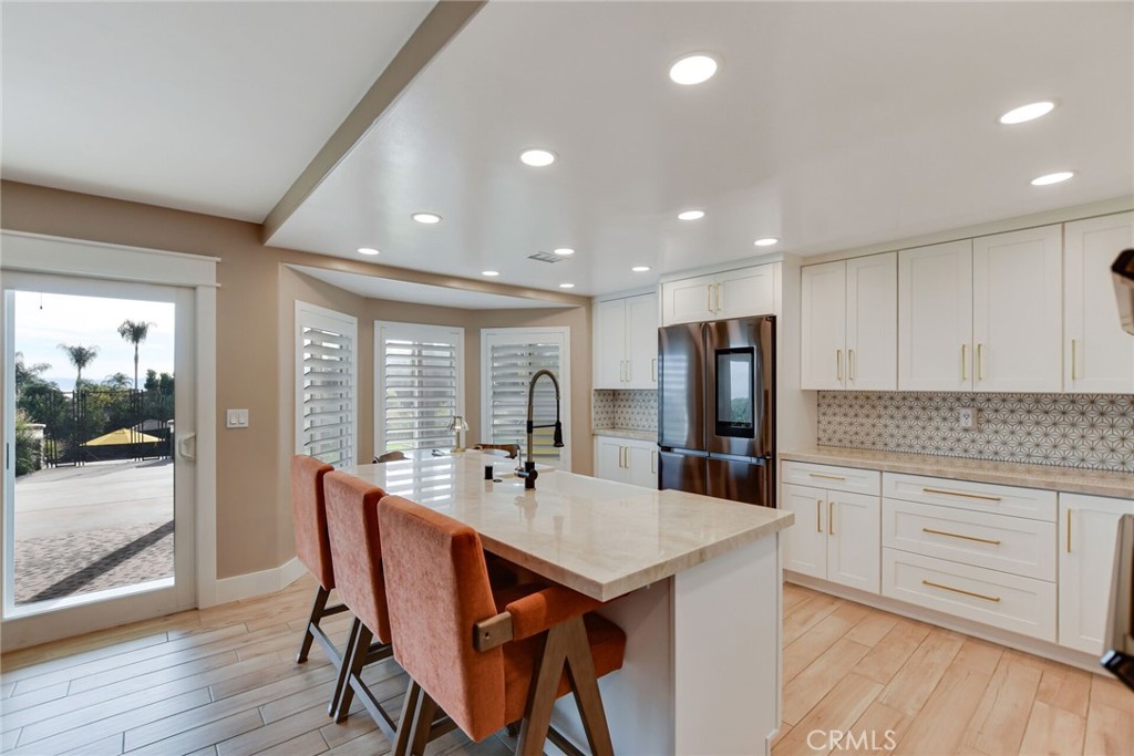 8317 La Senda Road Rancho Cucamonga, CA 91701 - Photo 23 of 75 a kitchen with stainless steel appliances kitchen island granite countertop a dining table chairs and granite counter tops