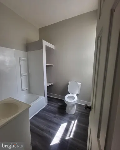 a bathroom with a bathtub sink and mirror