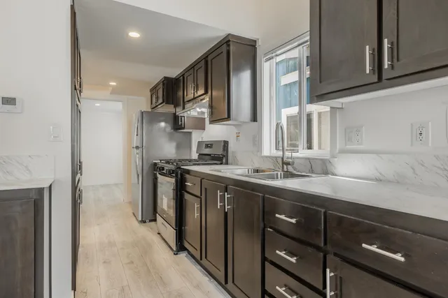 a kitchen with stainless steel appliances granite countertop a sink stove and refrigerator