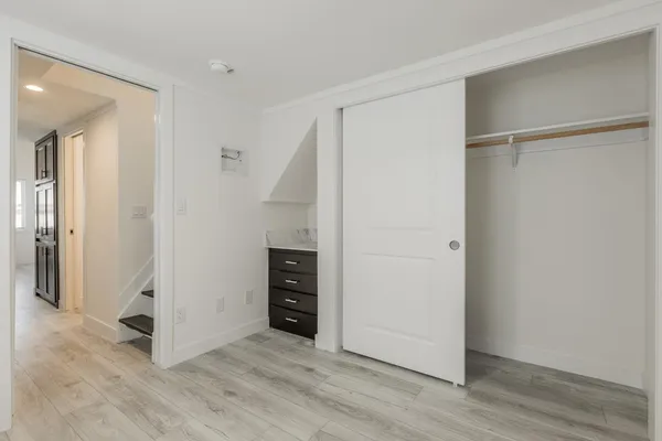 a view of an empty room with wooden floor