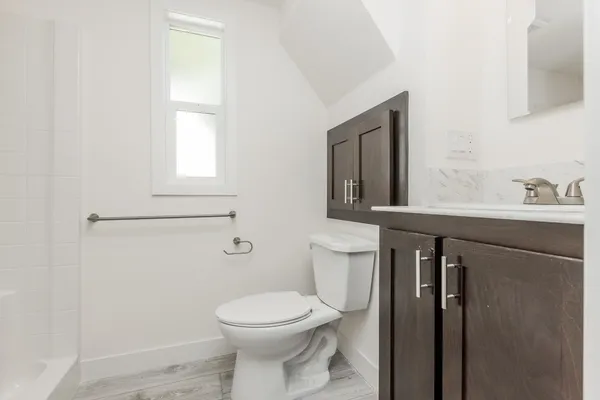 a bathroom with a toilet sink and mirror