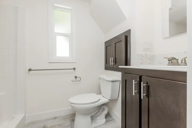 a bathroom with a toilet sink and mirror