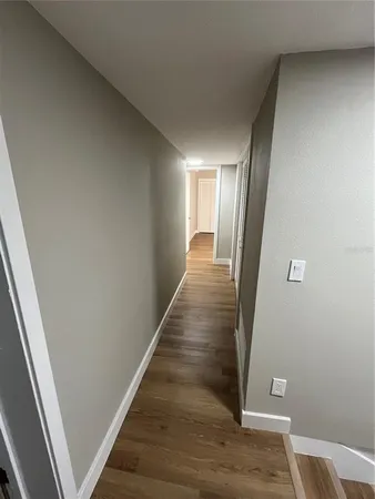 a view of a hallway with wooden floor