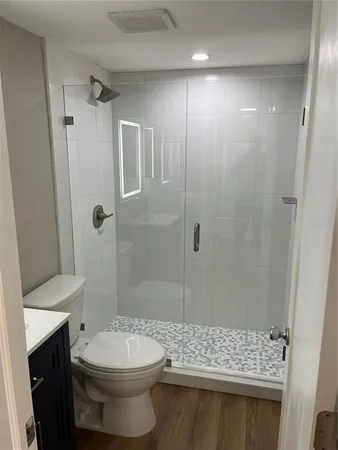 a bathroom with a sink a toilet and shower