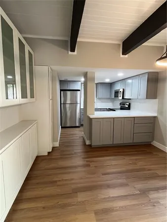 a kitchen with wooden floors and white walls