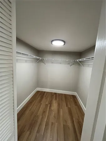 a view of a room with wooden floor and white walls