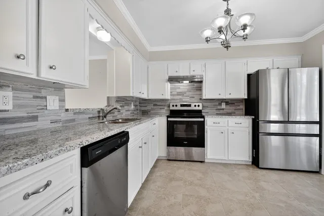 a kitchen with stainless steel appliances granite countertop a refrigerator stove a sink dishwasher and a refrigerator with wooden cabinets