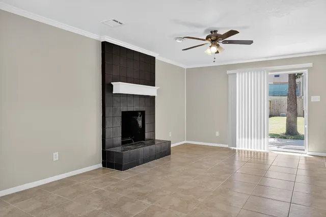 a living room with a fireplace and a ceiling fan
