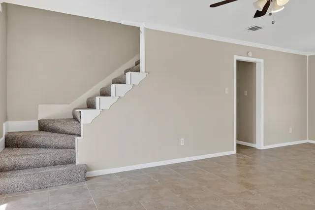 a living room with furniture and stairs