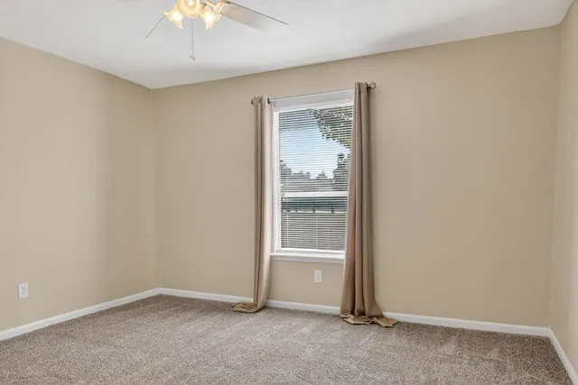 an empty room with a empty space and a ceiling fan