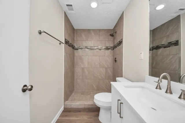 a bathroom with a sink toilet and shower