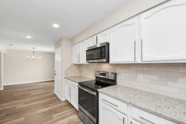 a kitchen with stainless steel appliances granite countertop a sink and a stove