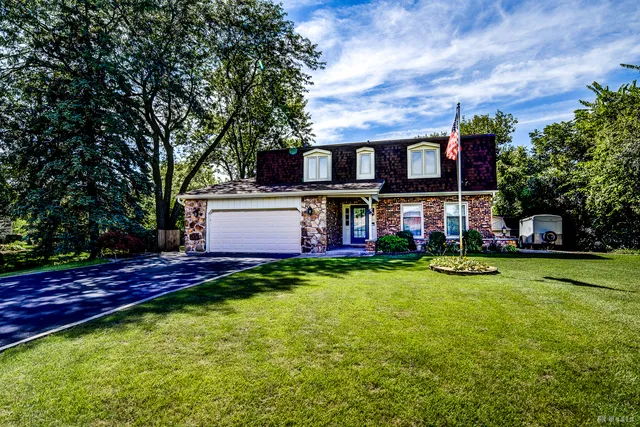 a view of a house with a big yard and large trees