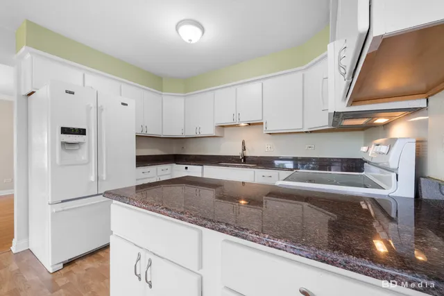 a kitchen with stainless steel appliances granite countertop a sink a refrigerator and a granite counter tops