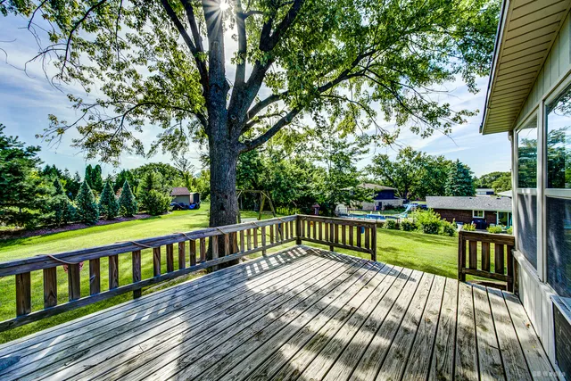 a view of a balcony with wooden floor next to a patio
