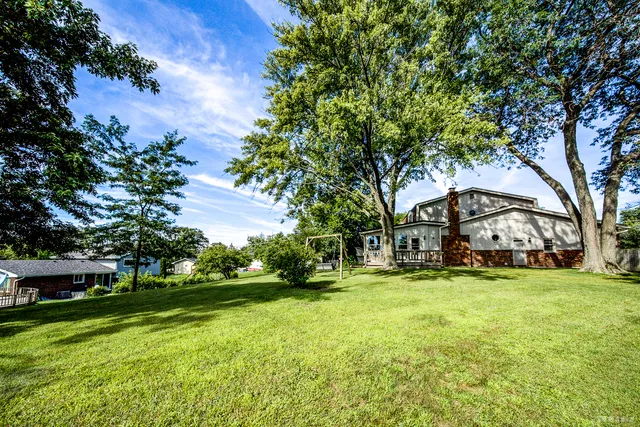 a view of a yard with plants and trees