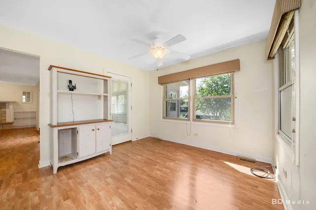 a view of an empty room with window and wooden floor
