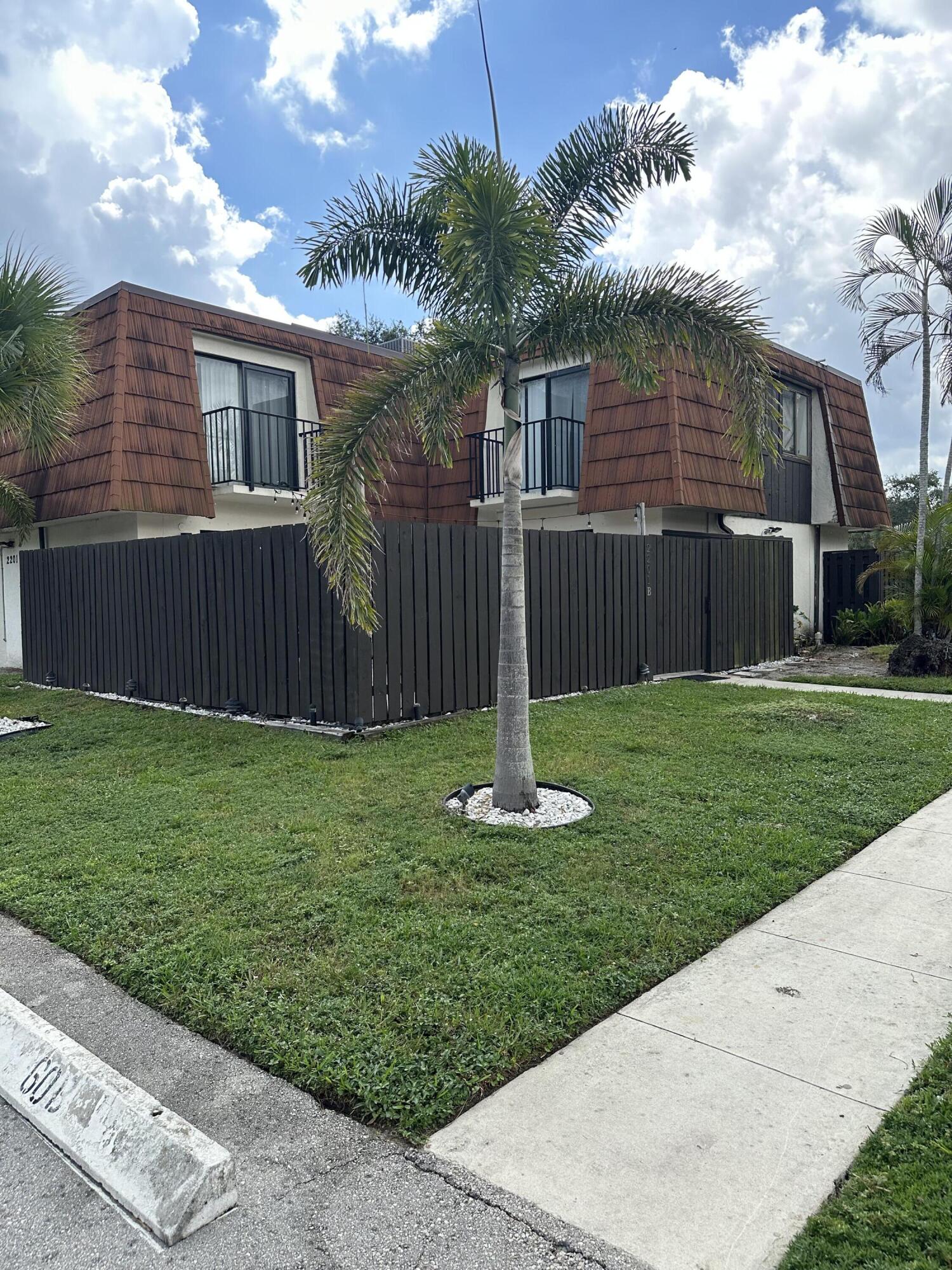 2201 White Pine Circle, Unit B Greenacres, FL 33415 - Photo 1 of 14 a front view of house with a garden