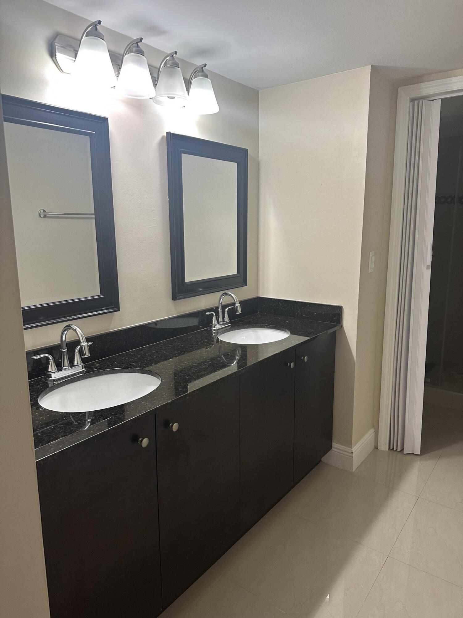 2201 White Pine Circle, Unit B Greenacres, FL 33415 - Photo 11 of 14 a bathroom with a sink and a mirror