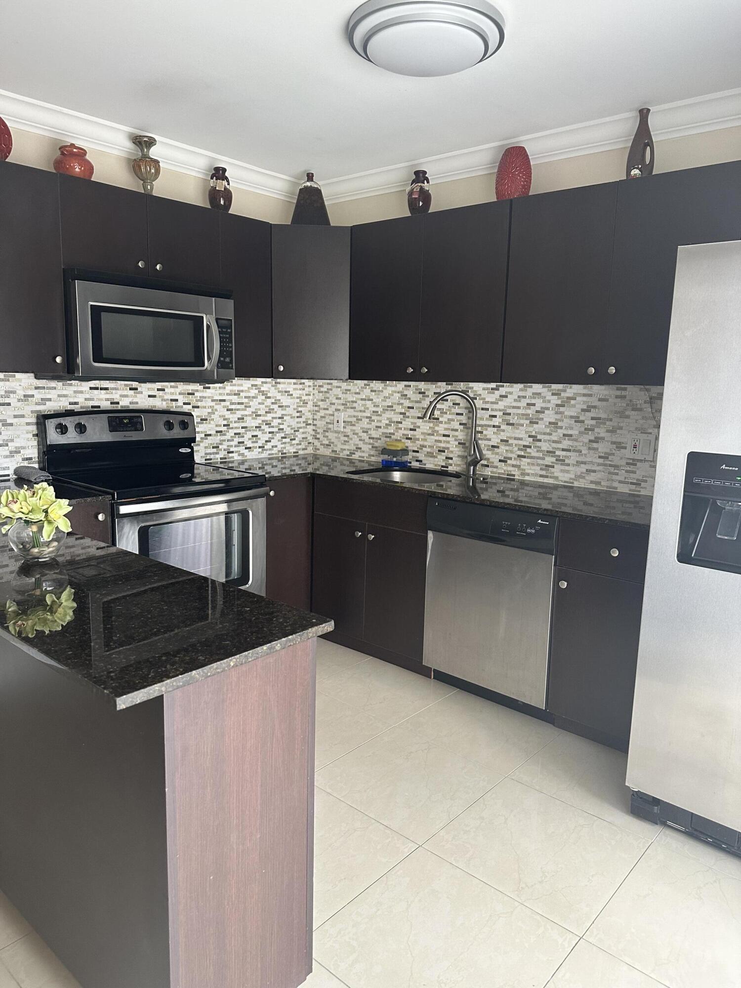 2201 White Pine Circle, Unit B Greenacres, FL 33415 - Photo 3 of 14 a kitchen with a sink and a stove