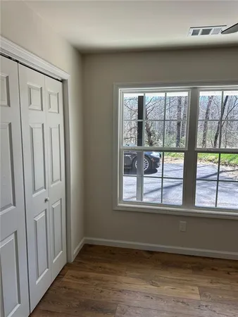 an empty room with wooden floor and windows