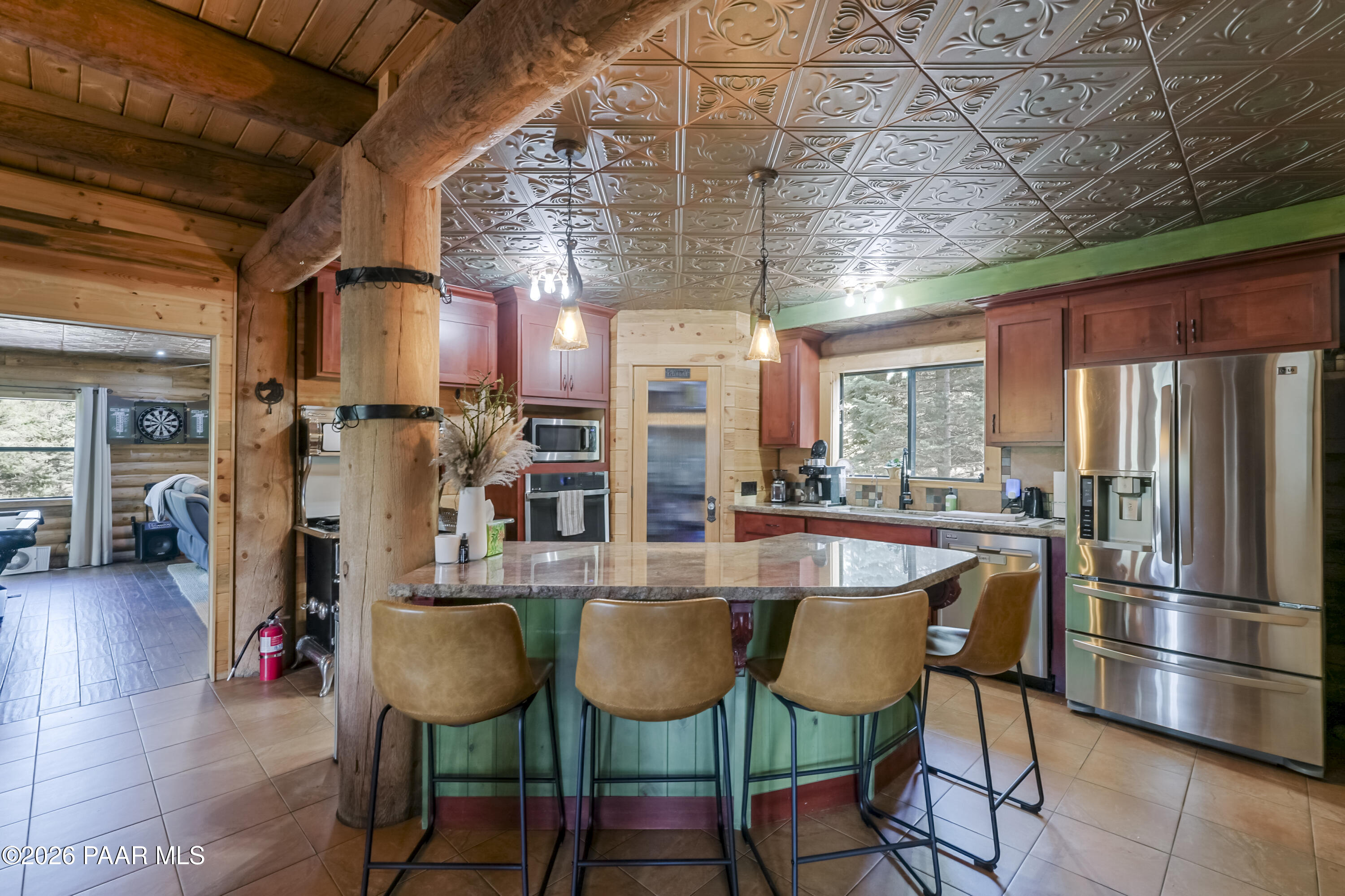 8105 South Comstock Mine Road Prescott, AZ 86303 - Photo 11 of 61 a dining room with stainless steel appliances kitchen island granite countertop a table chairs and a refrigerator