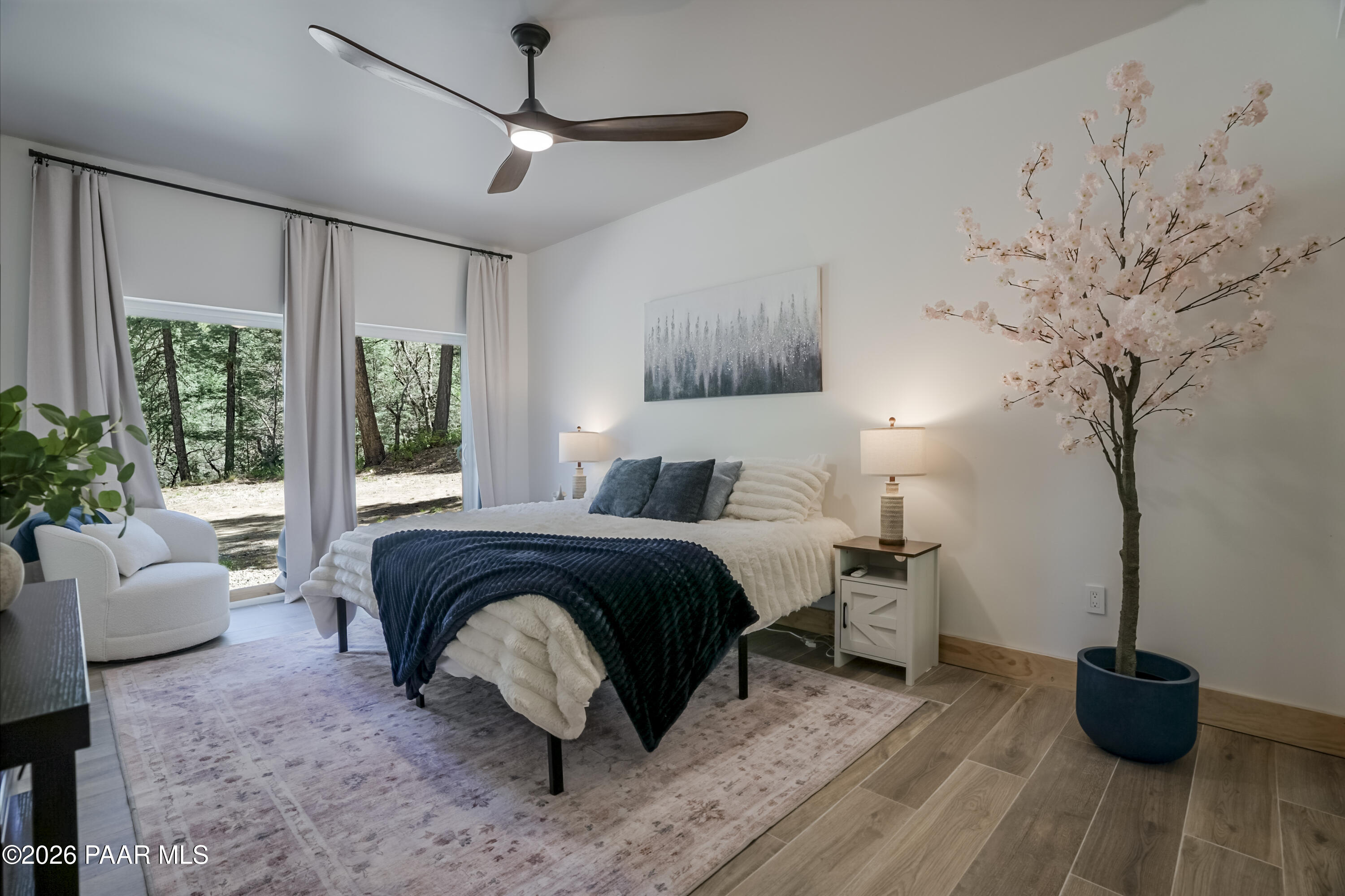 8105 South Comstock Mine Road Prescott, AZ 86303 - Photo 30 of 61 a spacious bedroom with a bed a couch and a potted plant