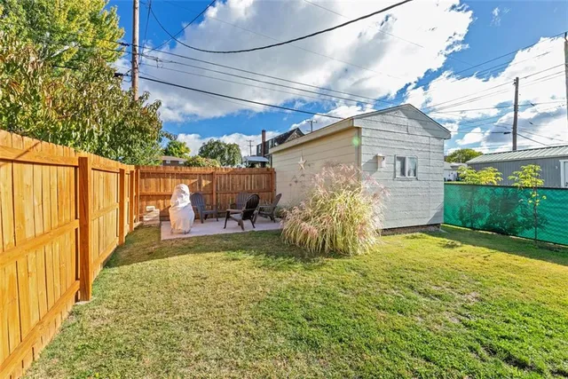 a view of a chair and table in backyard of the house