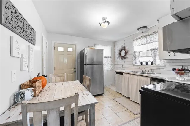 a kitchen with stainless steel appliances granite countertop a refrigerator a sink dishwasher a stove with white cabinets and wooden floor