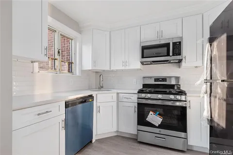 a kitchen with stainless steel appliances a stove microwave and sink