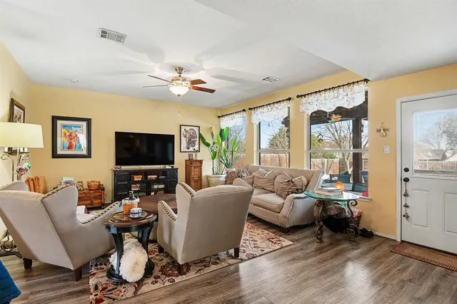a living room with furniture a flat screen tv and a large window