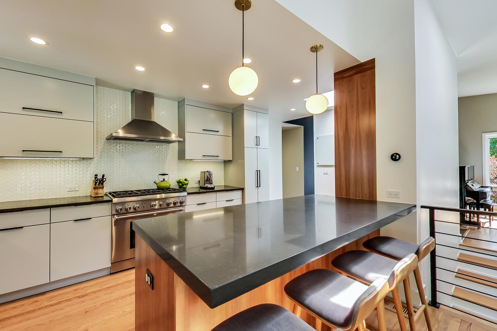 416 Maple Street Winnetka, IL 60093 - Photo 2 of 34 a kitchen with stainless steel appliances granite countertop a stove a sink a refrigerator white cabinets and chairs with wooden floor