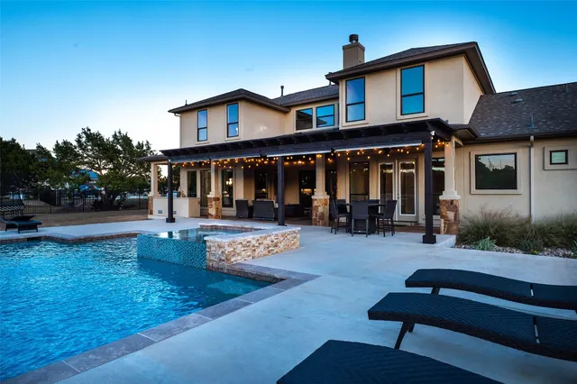 a kitchen with stainless steel appliances granite countertop a stove a refrigerator a sink a dining table and chairs with wooden floor