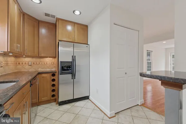 a kitchen with granite countertop a refrigerator and a sink