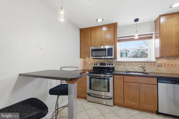 a kitchen with stainless steel appliances a stove a sink and a microwave