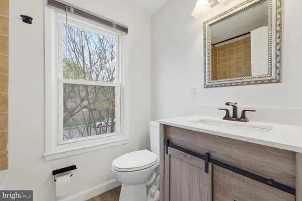 a bathroom with a sink vanity mirror and toilet