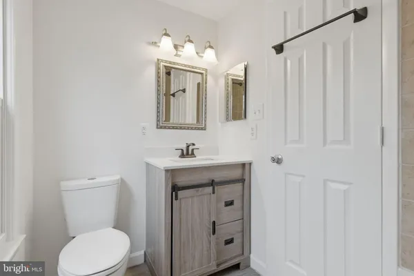 a bathroom with a toilet a sink and mirror