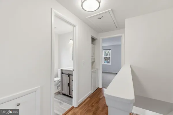 a view of hallway with bathroom and a sink