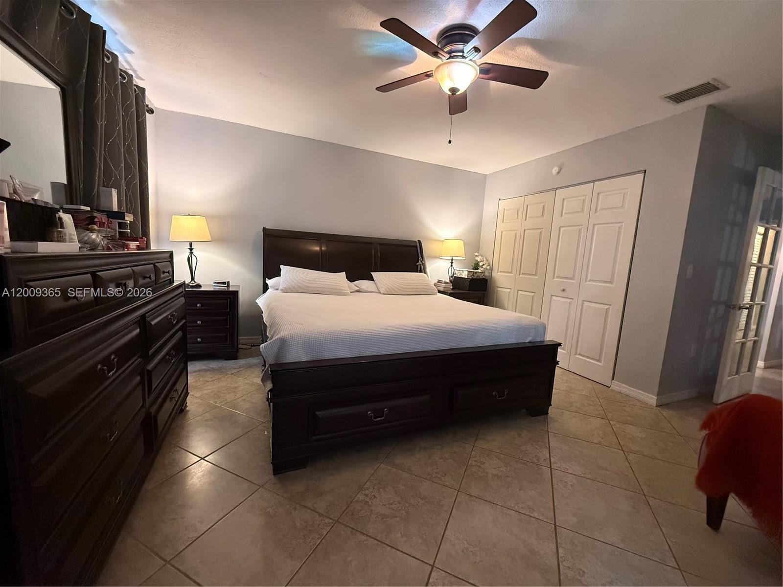 25835 Southwest 131st Court Homestead, FL 33032 - Photo 21 of 33 a bedroom with a bed and a chandelier
