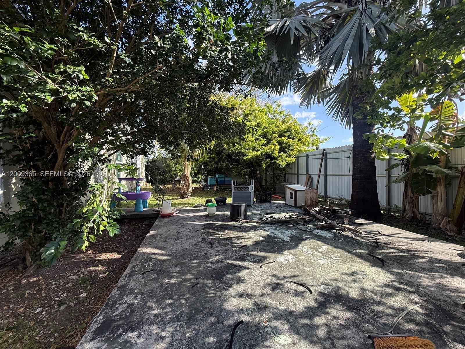 25835 Southwest 131st Court Homestead, FL 33032 - Photo 4 of 33 a view of a backyard with table and chairs under a large tree