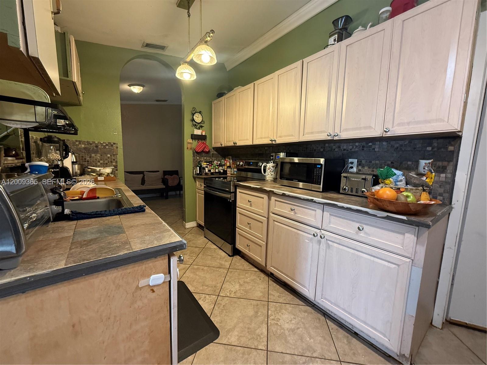 25835 Southwest 131st Court Homestead, FL 33032 - Photo 9 of 33 a kitchen with stainless steel appliances granite countertop a sink a stove and a refrigerator