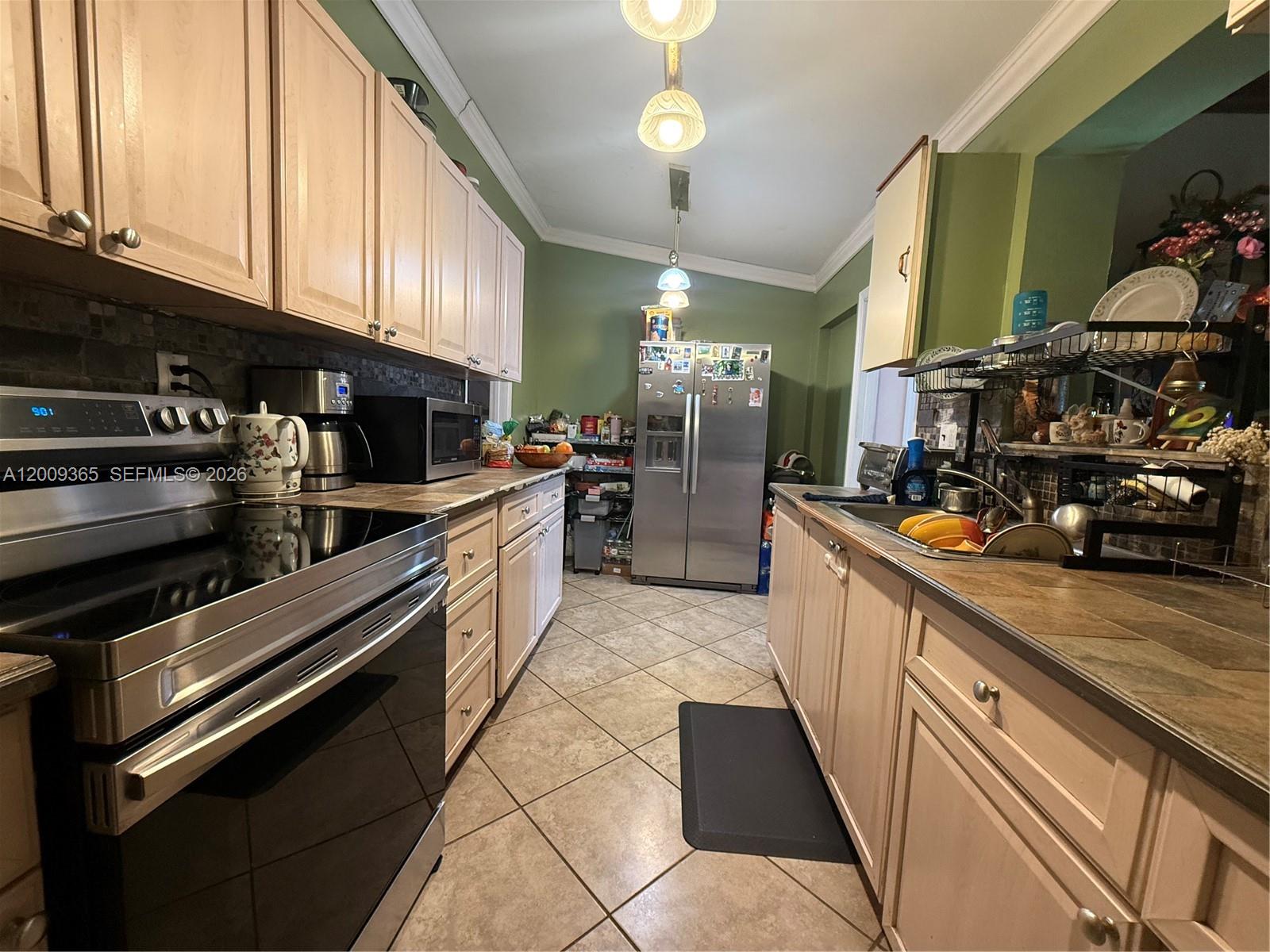 25835 Southwest 131st Court Homestead, FL 33032 - Photo 10 of 33 a large kitchen with stainless steel appliances granite countertop a stove and a sink