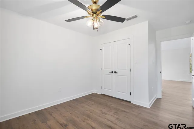an empty room with a window and a fan