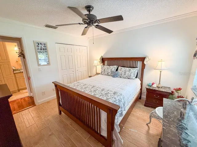 a bedroom with a large bed a flat tv screen and a window
