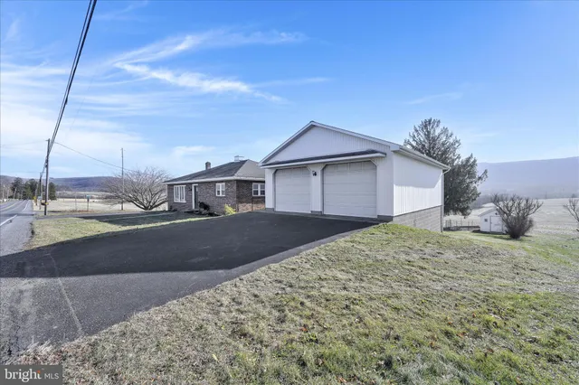 a view of a house with a big yard and large trees