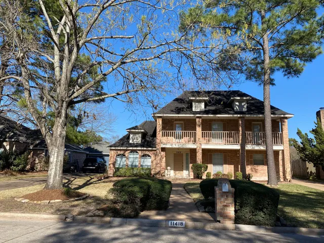 a front view of a house with a tree