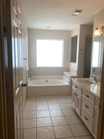 a bathroom with a bathtub sink and mirror