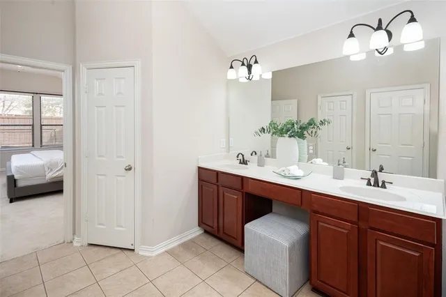 a en suite bathroom with a double vanity sink and a mirror